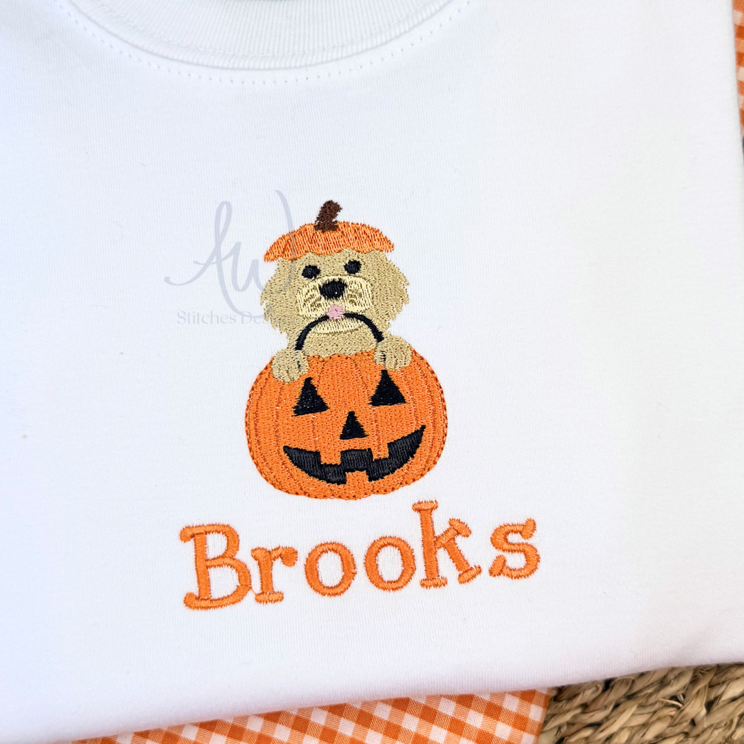 Embroidered design of a dog in a pumpkin with 'Brooks' text on a white background