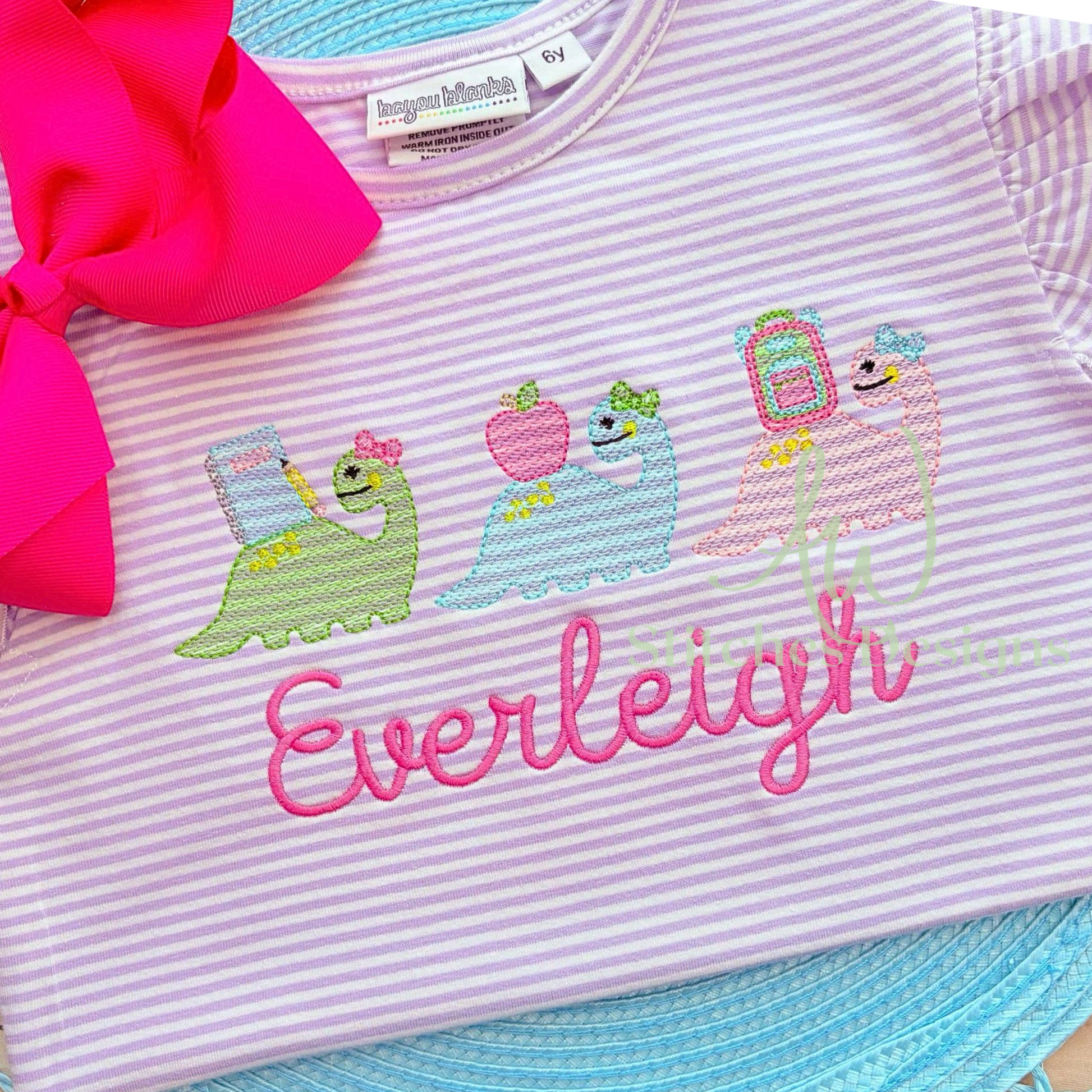 Children's shirt with embroidered designs and 'Everleigh' text, featuring a pink bow and blue trim.