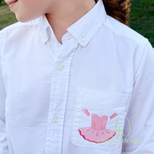 White shirt with pink ballerina design on a pocket, outdoors.