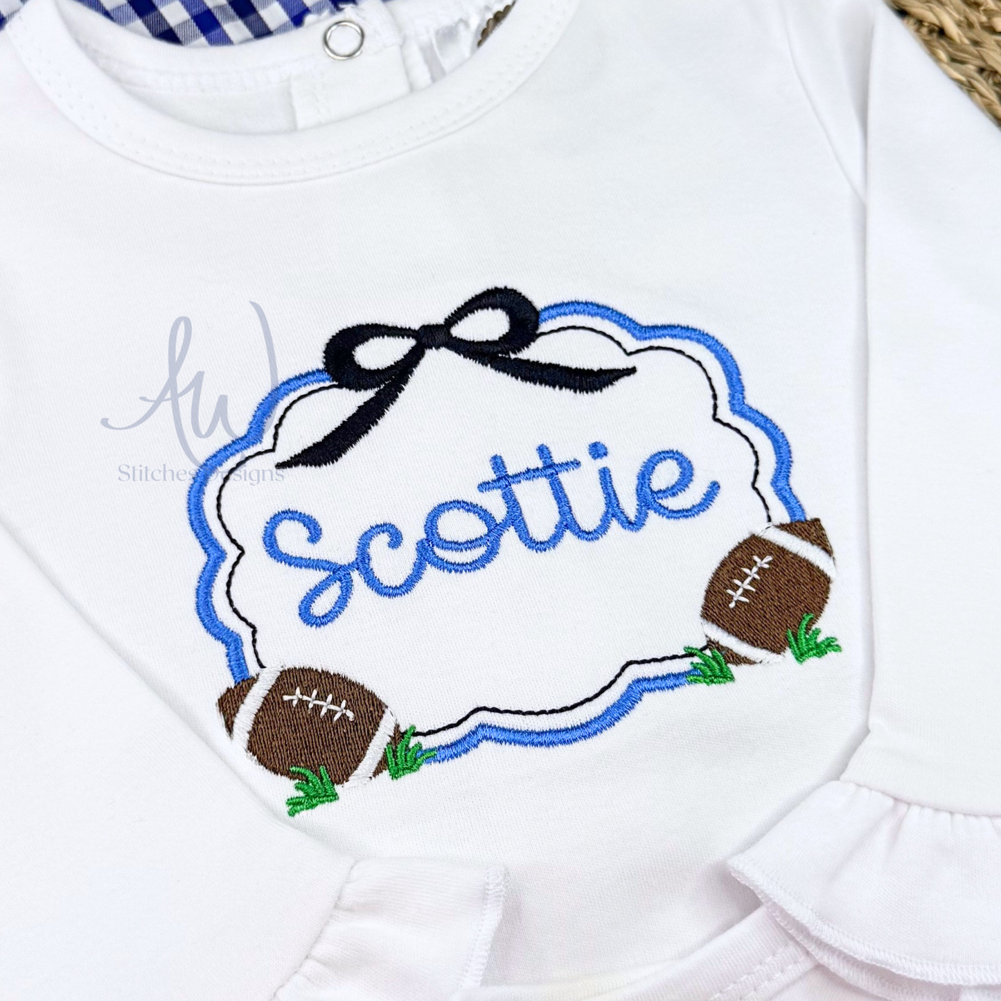 Close-up of girls football scallop frame embroidery with black bow and footballs