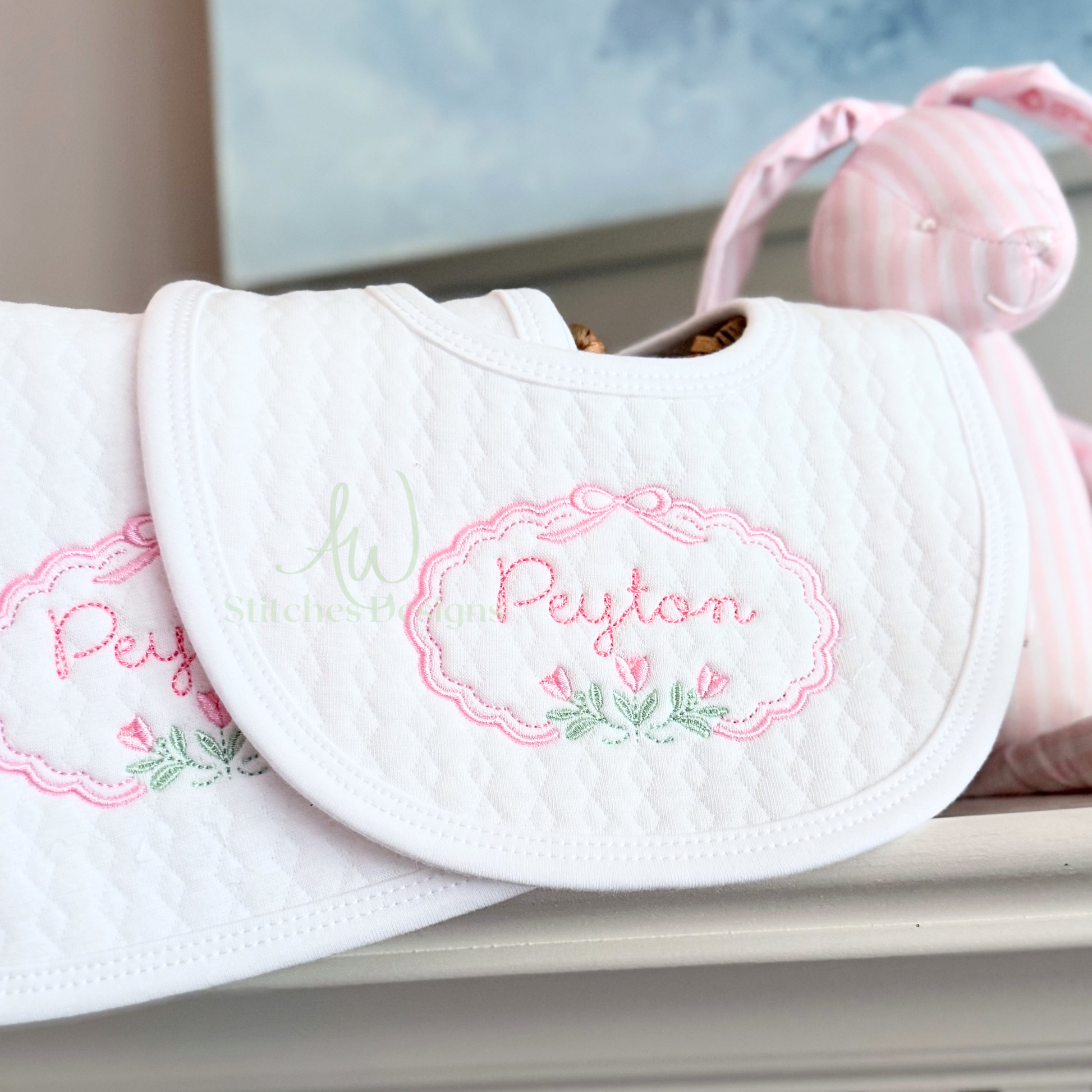 White bib with embroidered name 'Peyton' on a white surface