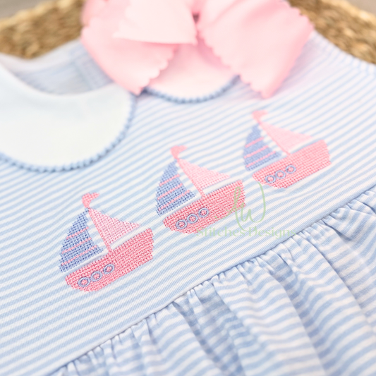 Children's dress with pink sailboat patterns on a blue and white striped background