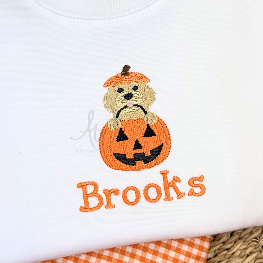 Embroidered design of a dog in a pumpkin with 'Brooks' text on a white background
