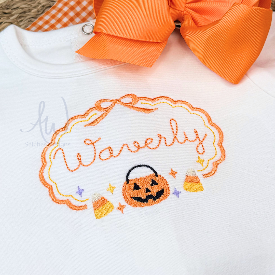 White baby bodysuit featuring an embroidered Halloween design with the name 'Waverly' in orange script inside an orange scalloped frame, a jack-o'-lantern, candy corn, and small stars. An orange ribbon bow is tied at the neckline.