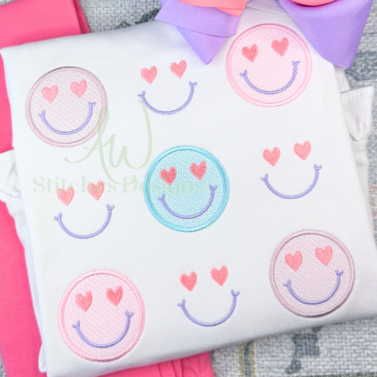 White pillow with smiley face designs and hearts on a pink and gray background