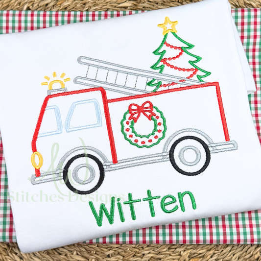Embroidered design of a Christmas-themed fire truck with tree and wreath on fabric.