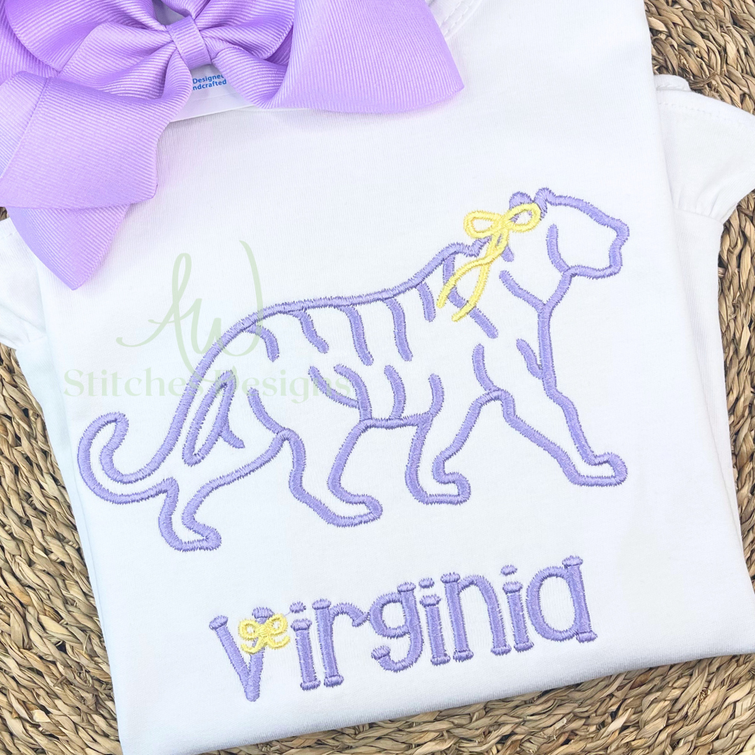 Girl tiger with bow machine embroidery design stitched on a white shirt in lavender and yellow thread