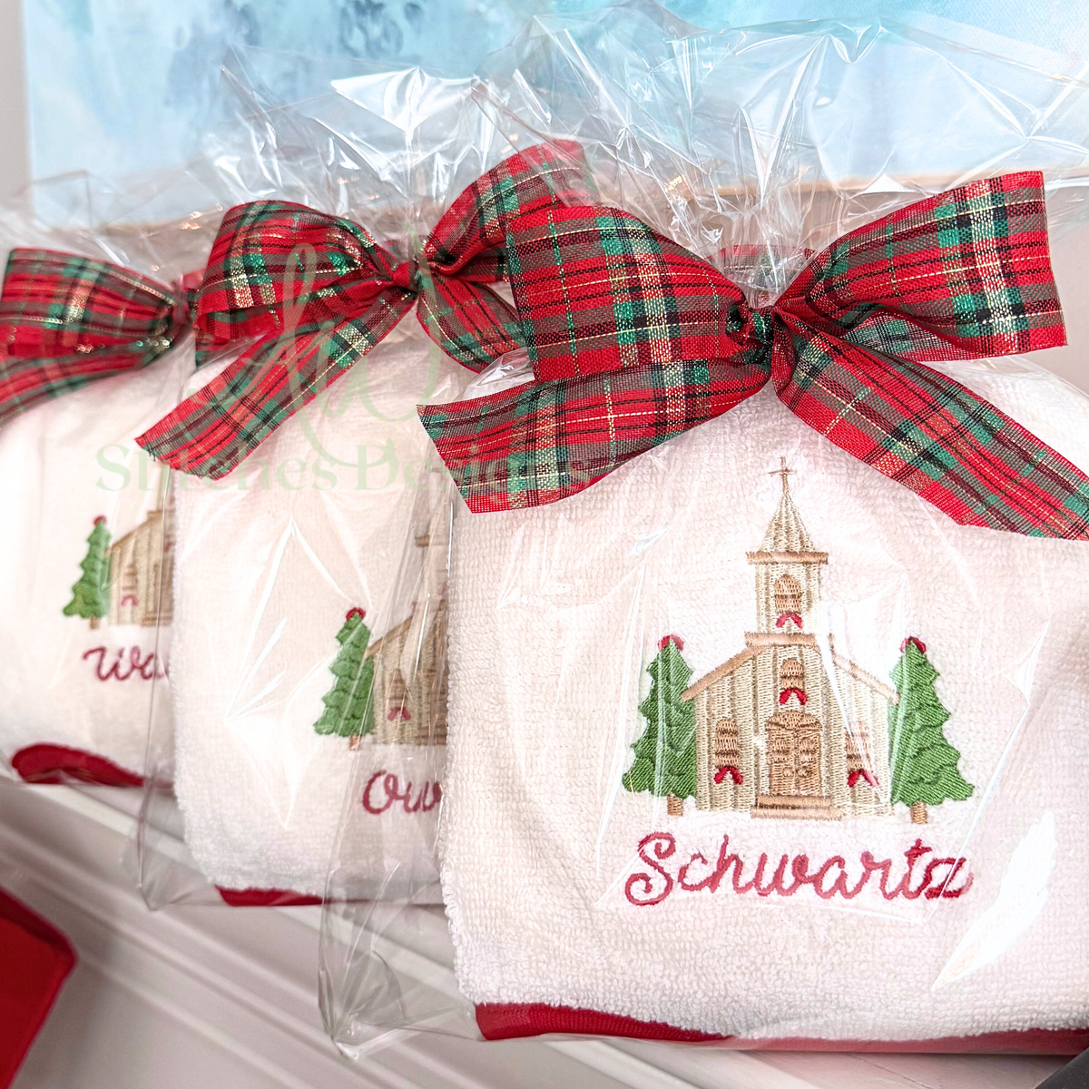 Christmas church machine embroidery design stitched on a holiday towel with plaid ribbon packaging