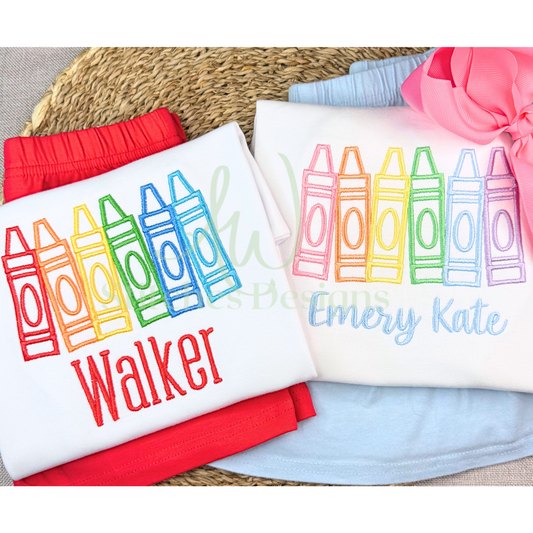 Children's clothing with colorful crayon designs and names embroidered on a textured surface.