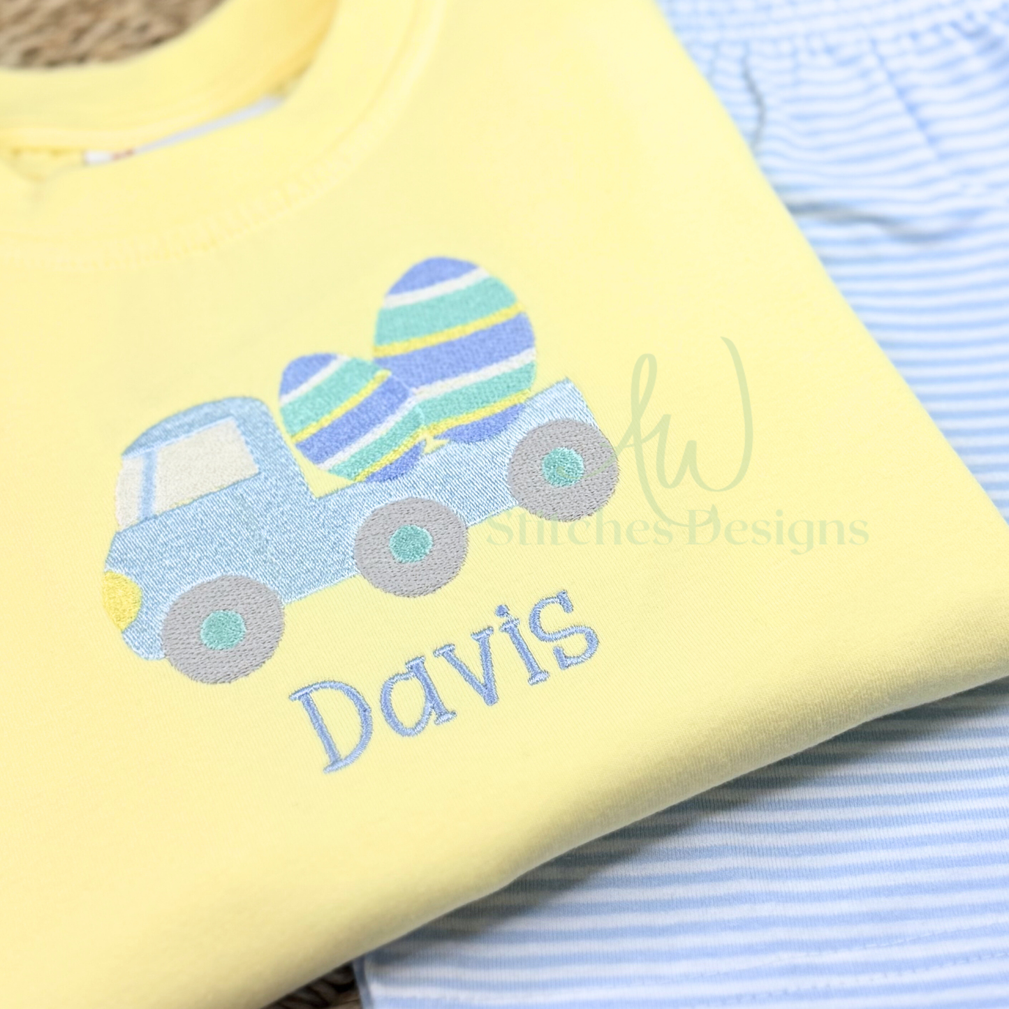 Yellow fabric with a blue truck and Easter eggs design, embroidered with 'Davis'.