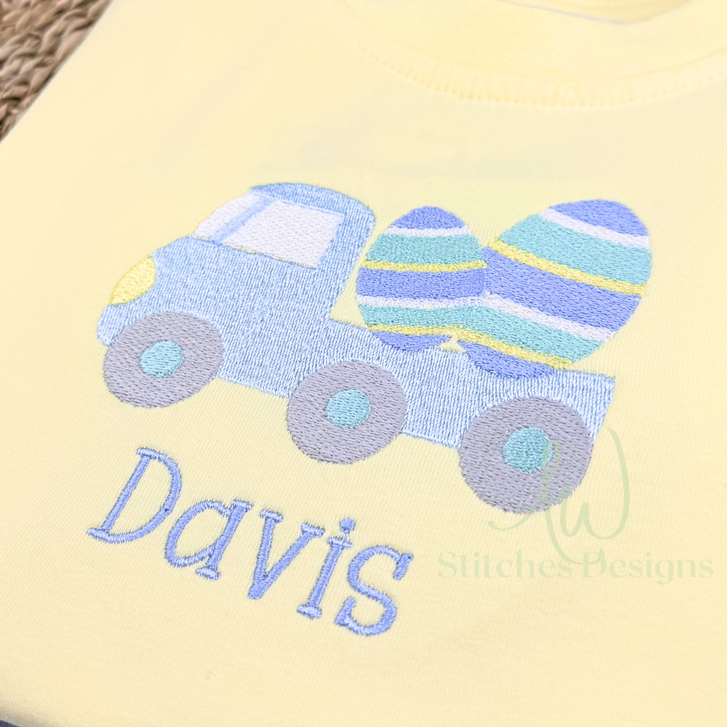 Yellow fabric with blue truck and Easter eggs design, embroidered with 'Davis'.