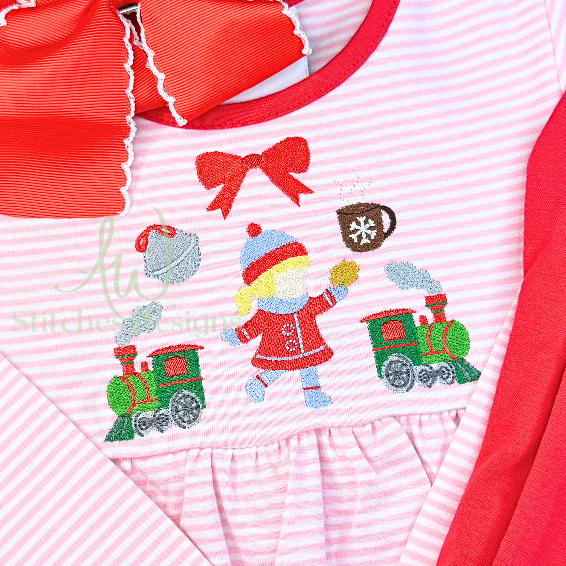 Children's outfit with embroidered design of a child in a red coat and hat, a green train, and a red bow on a pink and white striped background.