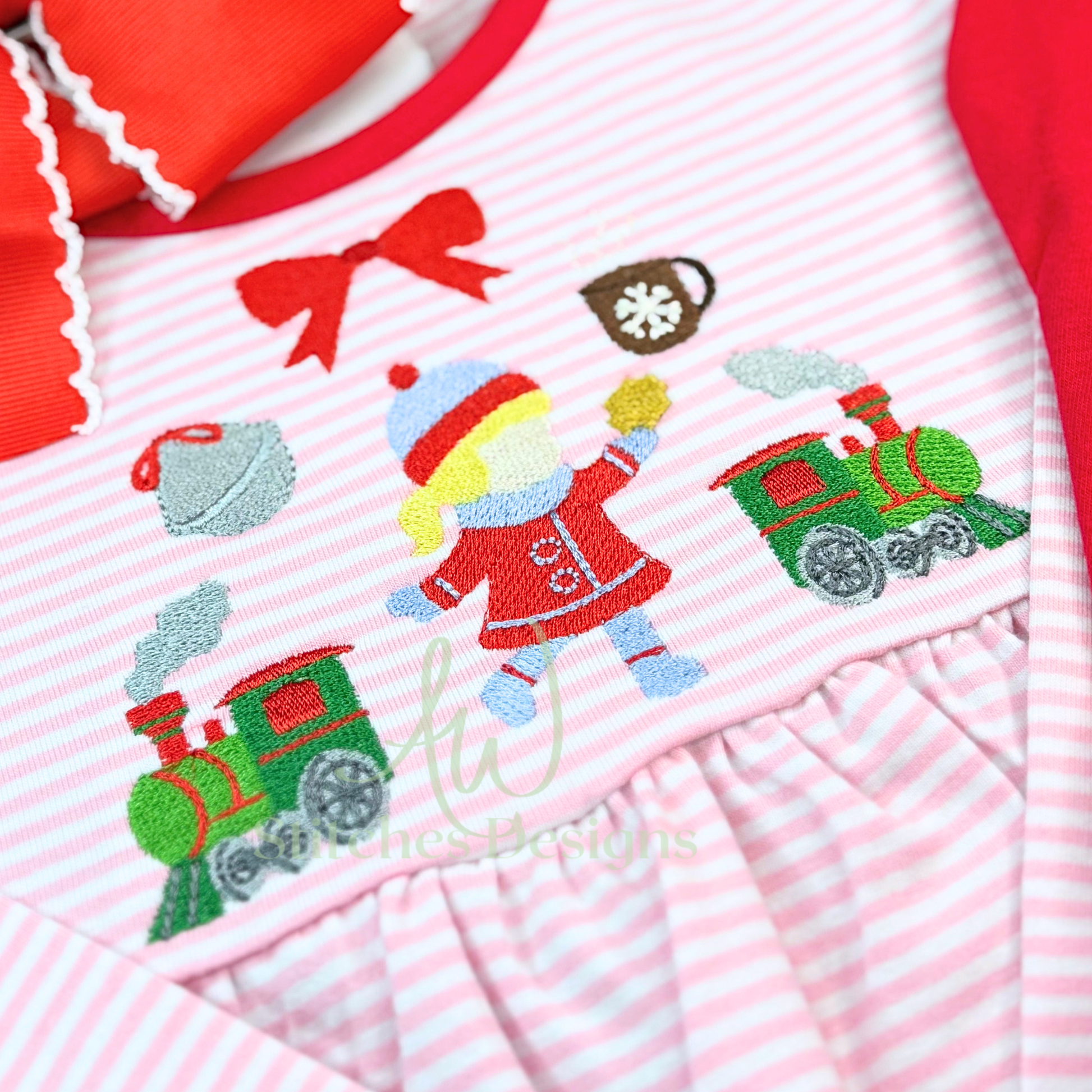 Children's outfit with embroidered design of a girl and train on pink and white striped fabric.