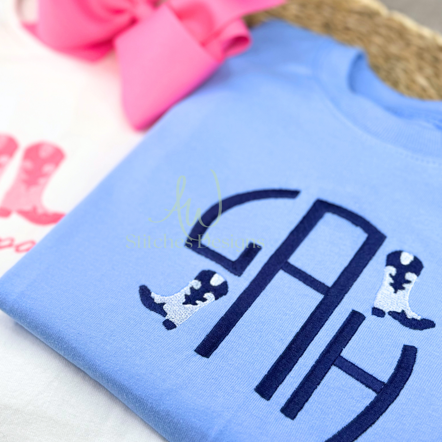 Light blue shirt with navy monogram and dog illustrations on a white surface.